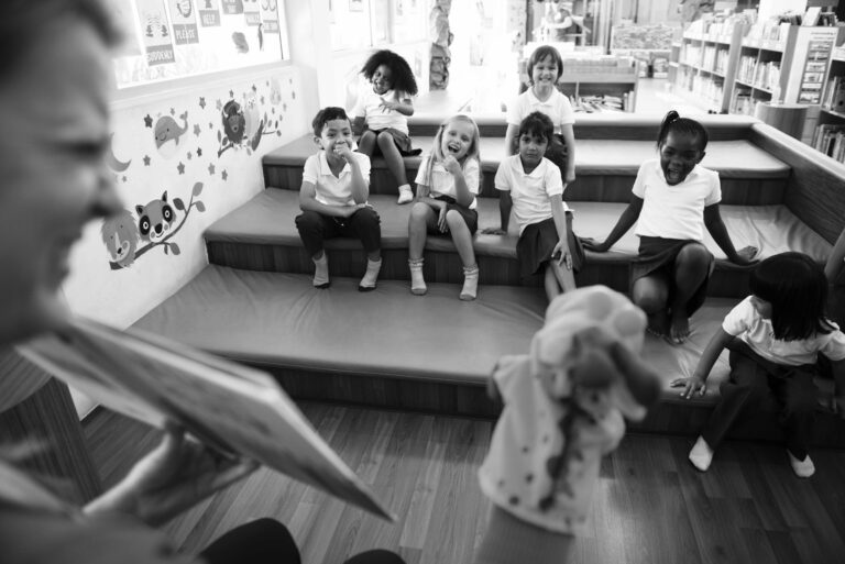 Kindergarten students sitting on the floor listening to story telling